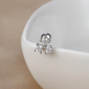 Macro shot of silver three-stone cluster earrings with secure screw-back ball closure
