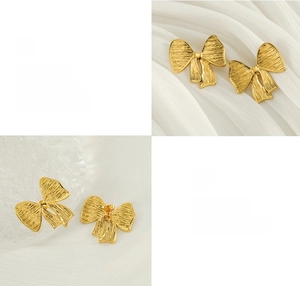 Vue détaillée des boucles d'oreilles nœud dorées avec texture froissée et finition polie