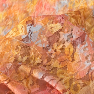 Macro shot of orange lace fabric with abstract floral prints and mesh texture