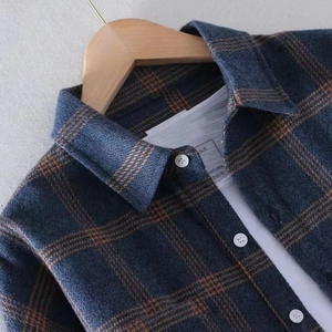 Dunkelblau-braunes Flanell-Karohemd an einem Holzbügel mit hochwertiger Texturdetails