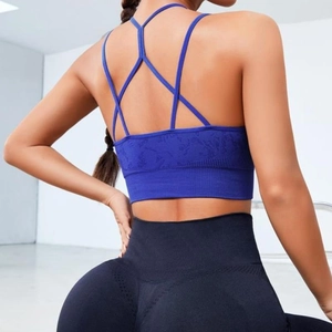 Brassière de sport bleue à dos croisé et legging de yoga noir vus de l'arrière du modèle