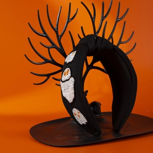 Halloween black fabric headband with white beaded ghost pattern on an orange background