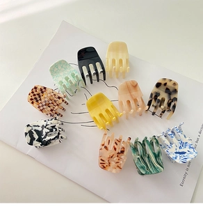 Macro view of assorted patterned acetate bow hair claws arranged on a white background