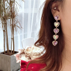 Long five-heart tassel earrings featuring pink crystals and rhinestones on a female model