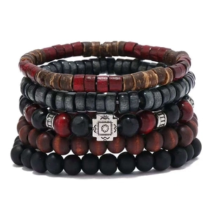 Macro detail of 6-layer stacked beaded bracelets featuring wood, stone, and metal charms