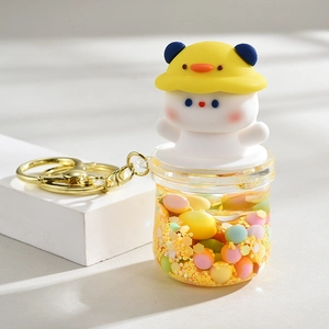Creative bear keychain with liquid sand bottle and colorful beads on a white surface
