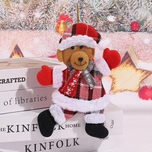 Close-up of Christmas teddy bear plush ornament with red plaid fabric and furry trim