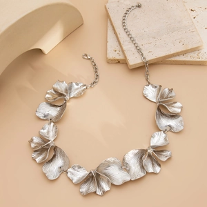 Detailed macro shot of textured silver ginkgo leaf metal necklace and lobster clasp