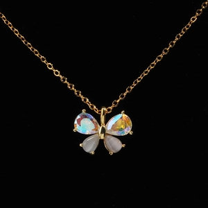 Close-up of gold-plated butterfly pendant with iridescent wings and cat-eye stone