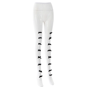 Détail du legging blanc texturé avec plusieurs petits nœuds noirs sur le côté des jambes
