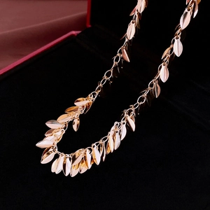 Close-up of golden leaf tassel necklace with polished metallic sequins in a jewelry box