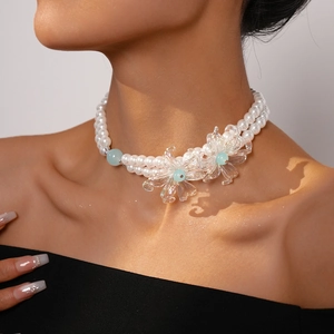 Detailed view of elegant double-layer pearl necklace with floral crystal pendants on neck