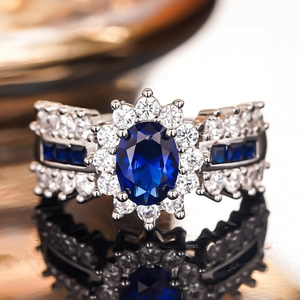 Makroaufnahme: Ovaler blauer Edelsteinring mit Zirkonia-Halo und diamantbesetztem Band