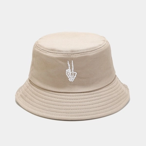 Close-up of beige bucket hat with skull hand peace sign embroidery and stitched brim