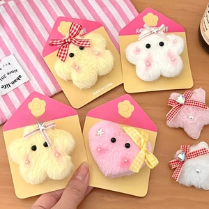 Close-up of plush star and flower hair clips set on colorful card packaging display
