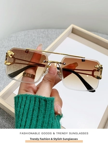 Close-up of golden leopard emblem and brown gradient lens on rimless sunglasses