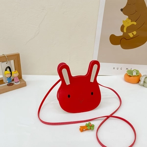 Detailed macro view of a red rabbit-shaped children's PU leather crossbody bag with long strap