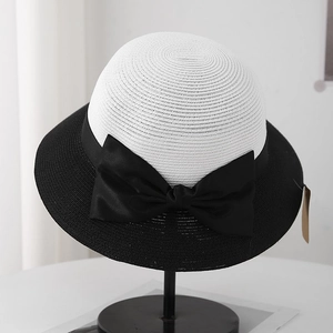 Detailed close-up of the fine texture and silk bow on a contrast woven sun hat