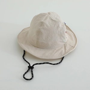Detail view of beige quick-dry bucket hat featuring adjustable drawstring and wide brim