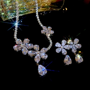Macro shot of sparkling silver flower necklace and earrings set with zircon teardrop charms