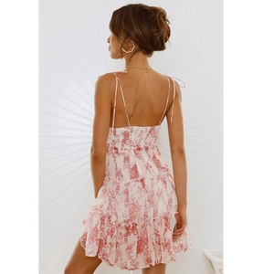Detailed back view of a white floral mini dress showing thin straps and open back design