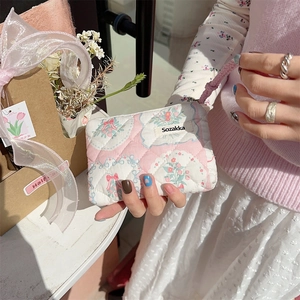 Close-up of a floral quilted cotton mini pouch held by hand for lipstick and cards