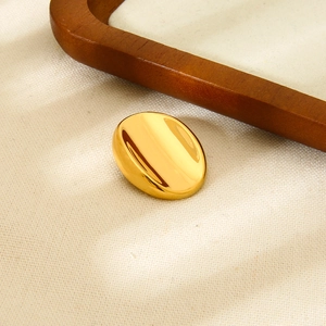 Detailed view of an 18k gold plated ribbed round brooch on textured fabric background
