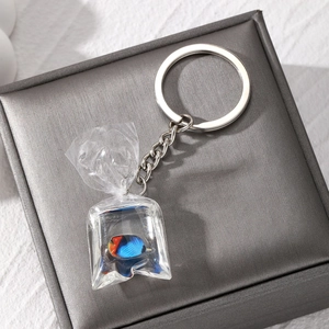 Macro detail of tropical fish resin keychain featuring a clear water bag pendant