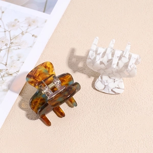 Elegant geometric acetate hair claws in amber tortoise and white marble textures