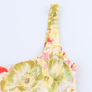 Close-up of summer linen dress featuring vintage floral patterns and shoulder straps