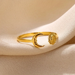 Macro shot of gold sun and moon adjustable ring on soft beige textured fabric background