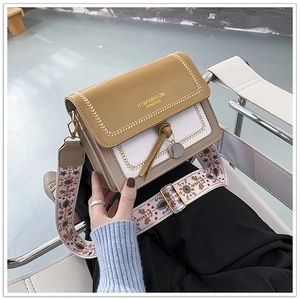 Detail of khaki and white color block crossbody bag with patterned fabric strap