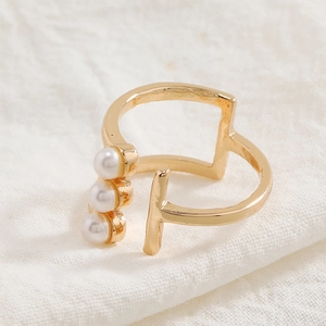Minimalist gold adjustable ring featuring three vertical pearls and a T-shaped design