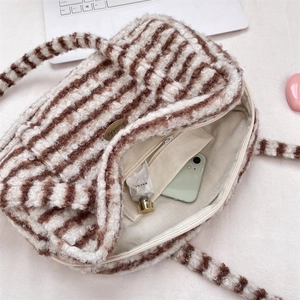 Détail du sac Boston rayé en peluche montrant la poche intérieure et la texture douce