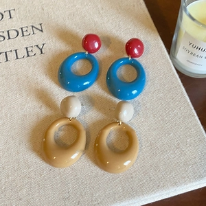 Vintage caramel resin geometric hoop earrings displayed on a rustic book surface