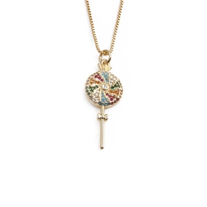 Golden lollipop pendant necklace with colorful gemstones and bow on white background