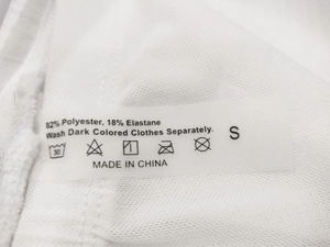 Gros plan de l'étiquette d'entretien sur le short de sport en maille blanche avec détails