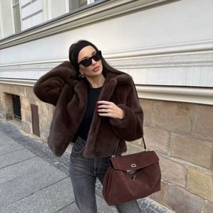 Women's trendy short brown faux fur coat with lapel collar in a stylish street fashion look
