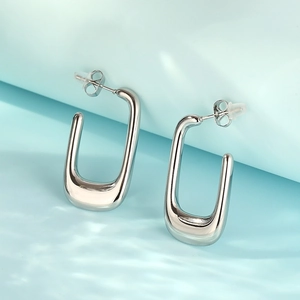 Macro detail of silver U-shaped stainless steel earrings with butterfly backing