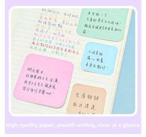 Close-up of colorful square sticky notes applied on a lined notebook for office use