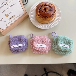 Vista dettagliata di mini custodie in peluche per auricolari in un ambiente accogliente