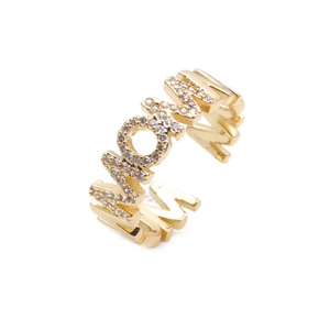 Macro detail of gold MOM ring featuring pave-set sparkling zircon stones on a white background