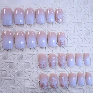 Short Christmas press-on nails with white snowflake patterns and pink ombre effect