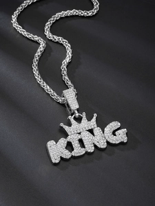 Detailed macro view of silver KING crown pendant with sparkling crystals on twist chain