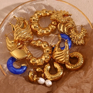 Macro view of gold plated vintage hoop earrings with resin and pearls in glass