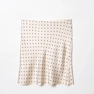 Jupe élégante en satin à pois crème et noir avec une texture soyeuse et lisse