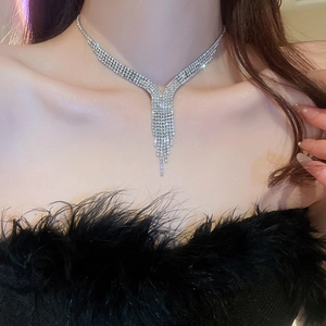 Dettaglio della collana di strass argento a forma di V con nappe a frangia luccicanti