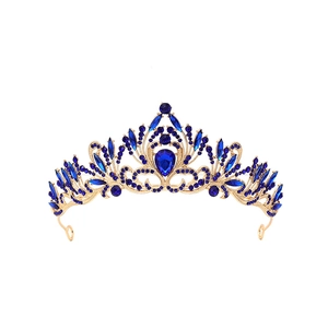 Detail of baroque gold tiara featuring deep blue teardrop rhinestones and ornate patterns