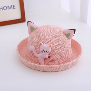 Détail d'un chapeau de paille rose avec oreilles de chat 3D et broderie pour enfant