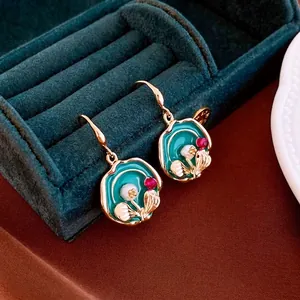 Vintage gold plated enamel pearl and crystal drop earrings on green velvet box